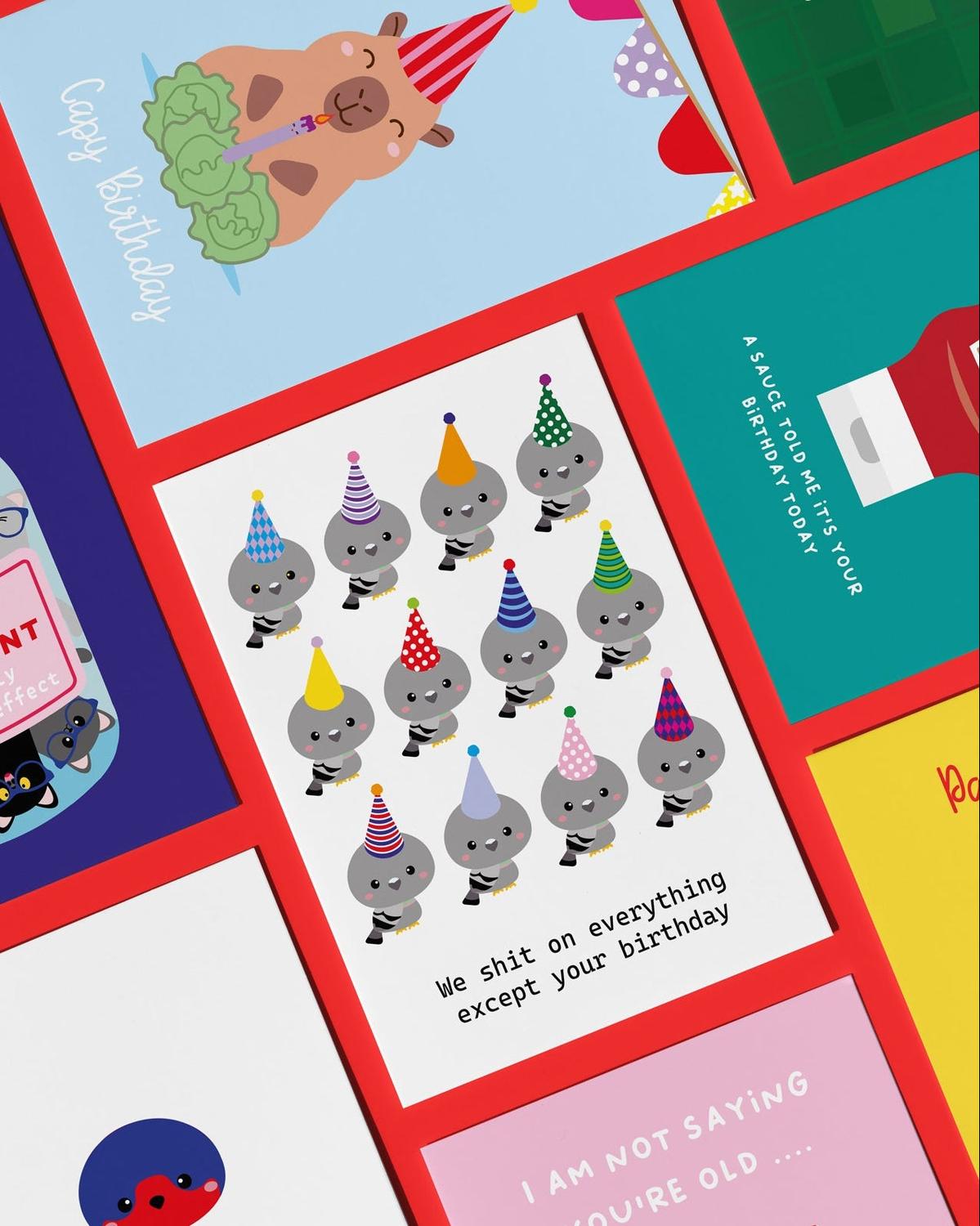 White birthday card with 12 cartoon pigeons in party hats and "We shit on everything except your birthday.