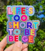 Glitter sticker met "Life's Too Short To Be Beige" in felle, kleurrijke letters.