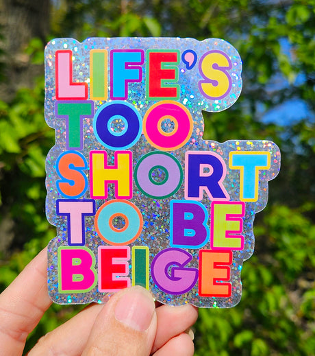 Glitter sticker met "Life's Too Short To Be Beige" in felle, kleurrijke letters.