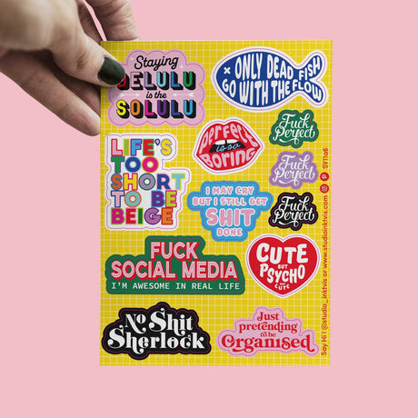 A6 vinyl stickervel met 11 kleurrijke, brutale quotes zoals "Delulu is the Solulu" en "Cute but Psycho".