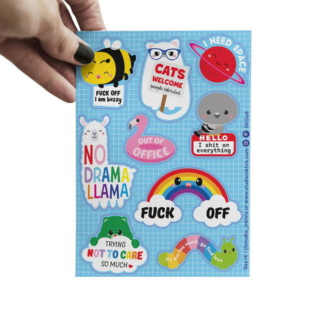 Hand houdt een stickervel met 11 brutale, kleurrijke cartoonfiguren, waaronder een lama, bij en regenboog, op een blauw raster.