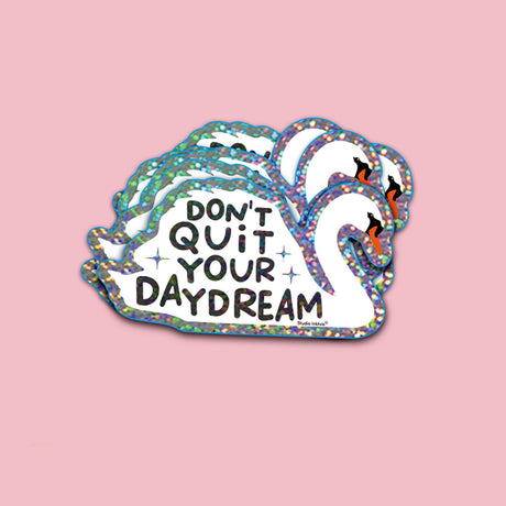 Witte zwaan glittersticker met "Don't Quit Your Daydream" tekst op een roze achtergrond.