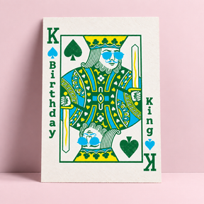 RISO-verjaardagskaart met koning-illustratie in groen, blauw en geel, in de stijl van een speelkaart met zonnebril.