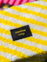 Geel-wit gestreept teddy tasje met zwart label en gouden tekst random crap