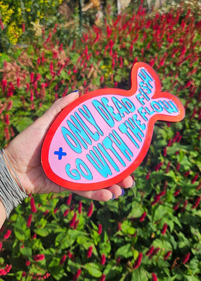 Visvormige wandspiegel van roze en rood acrylaat met blauwe tekst Only dead fish go with the flow, 20 cm.