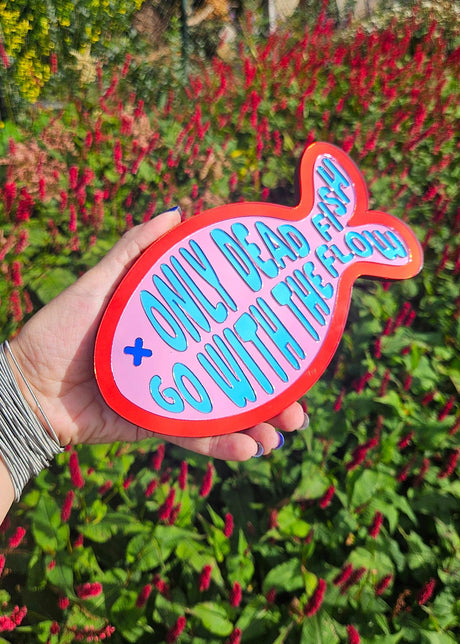Visvormige wandspiegel van roze en rood acrylaat met blauwe tekst Only dead fish go with the flow, 20 cm.